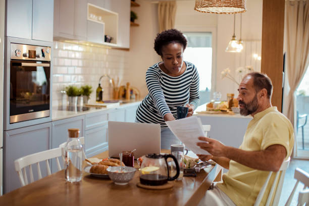 istock Mid adult couple going over their home finances while having breakfast 1450019977