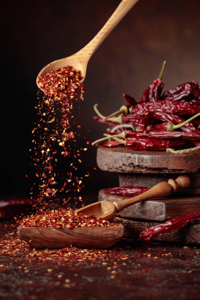 istock Chilli flakes are poured into a wooden dish. 1450020765