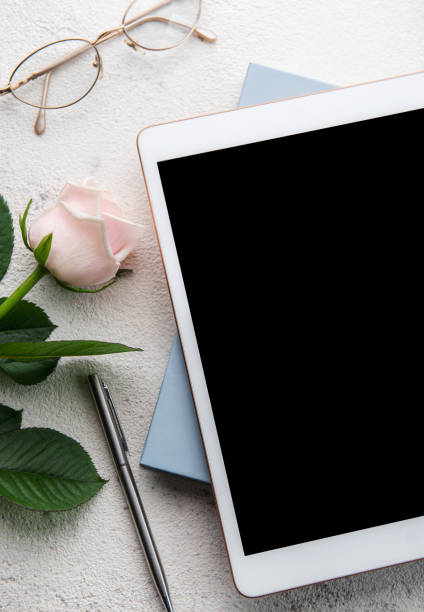 istock Bouquet of roses and tablet  on concrete background. 1450024428