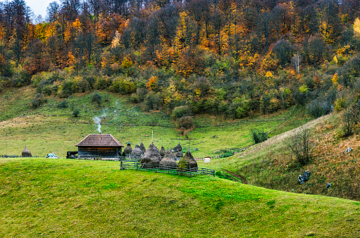 Wooden hut and haystacks in the Carpathian Mountains. Transylvania, Romania, Europe.