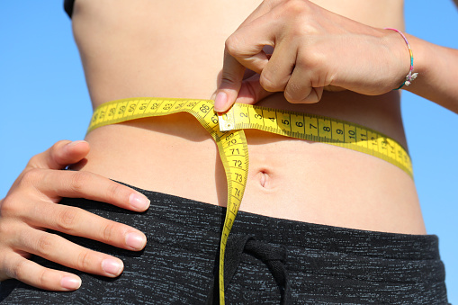 young girl belly waist measurement with tape measure and measure in centimeters