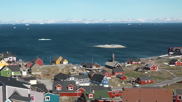 The colorful settlement in central-western Greenland. A typical village in Greenland with colorful houses. Greenlandic fishing town, Old wooden church, town life, beautiful series of Arctic life.
