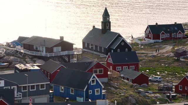 The colorful settlement in central-western Greenland. A typical village in Greenland with colorful houses. Greenlandic fishing town, Old wooden church, town life, beautiful series of Arctic life.
