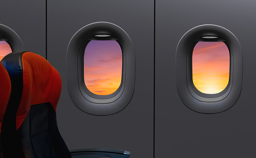 Windows and seats inside airplane while flying on sunrise sky at morning time, View from inside cabin while turn off the lights