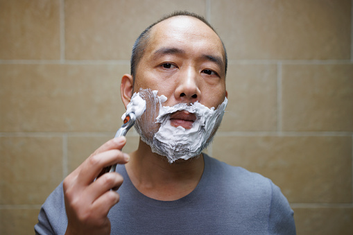 asian middle aged men shave with a razor
