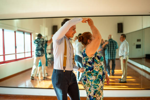 Dancing teacher teaching senior woman at a class in a dance studio