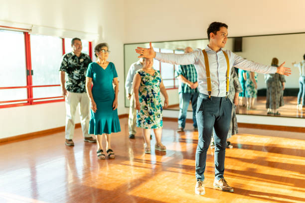 istock Young dancing instructor giving a class to a group of mature students at a dancing studio 1450034718