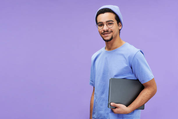 young smiling businessman or student in blue t-shirt and beanie - afgelegen stockfoto's en -beelden