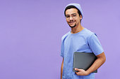 Young smiling businessman or student in blue t-shirt and beanie