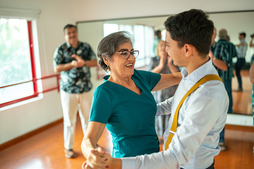 Senior woman dancing with dancing instructor at a dance studio