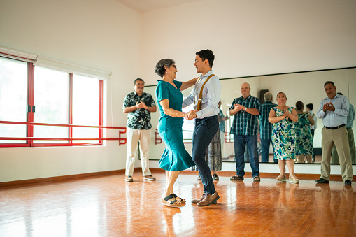Senior woman dancing with dancing instructor at a dance studio