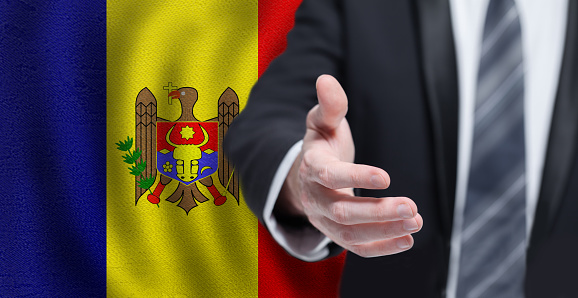 Moldova business, politics, cooperation and travel concept. Hand on flag of Republica Moldova background.
