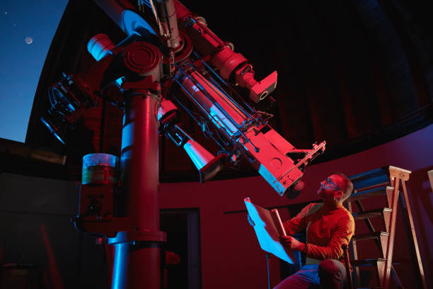 istock Astronomer with a big astronomical telescope in observatory doing science research of space and celestial objects. 1450037699