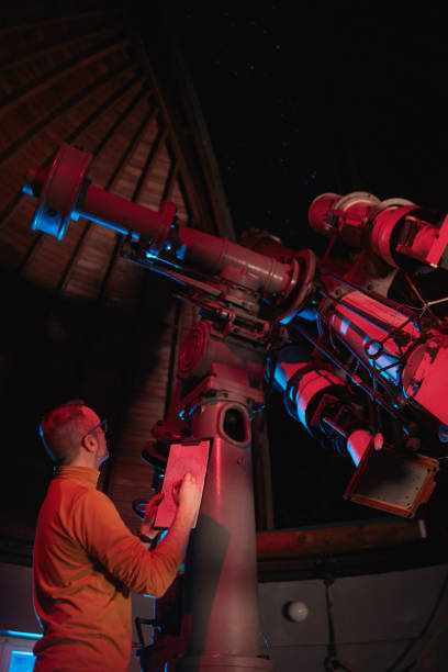 istock Astronomer with a big astronomical telescope in observatory doing science research of space and celestial objects. 1450037737