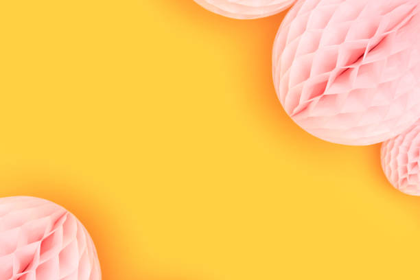 istock Pink tissue paper balls on a yellow background. 1450037975