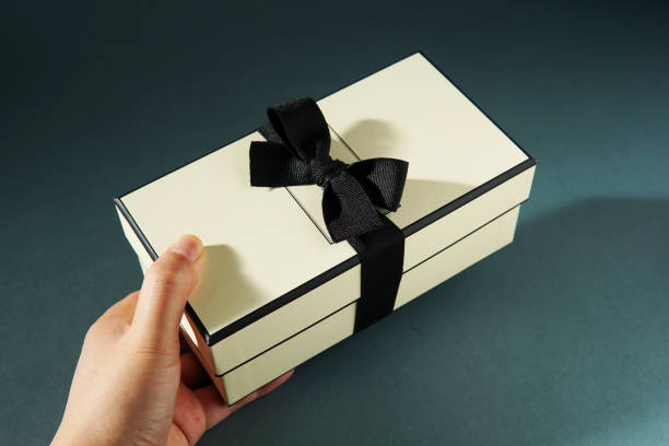 istock Hand holding a gift box against green background. 1450039187