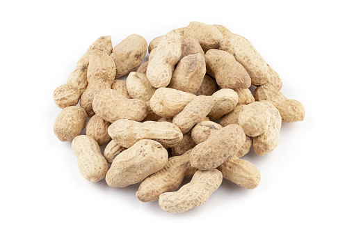 Heap of peanuts in shell isolated on white background. Eating peanuts snack food concept.