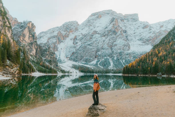 woman standing near  lago di braies in winter - tourist resort lake italy scenics imagens e fotografias de stock