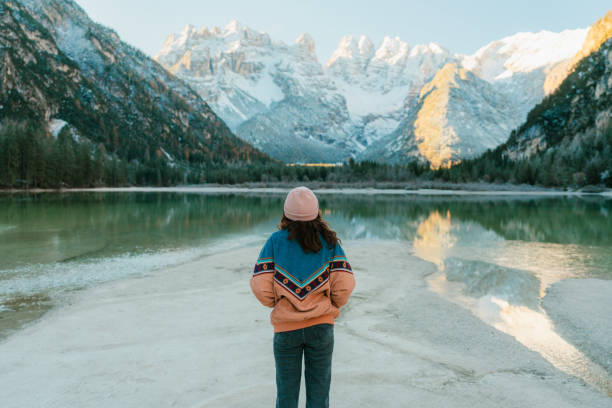 mujer parada cerca del lago di braies en invierno - swiss winter fotografías e imágenes de stock