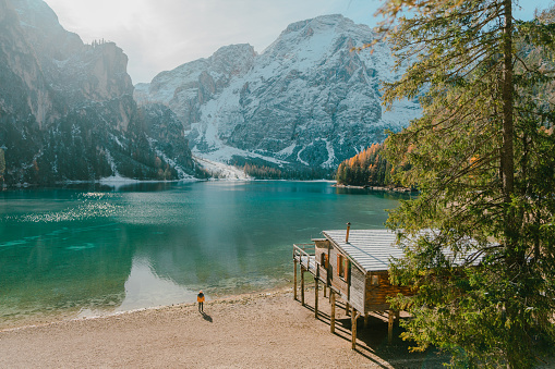 Young Caucasian woman standing on the background of   Lago di Braies in winter