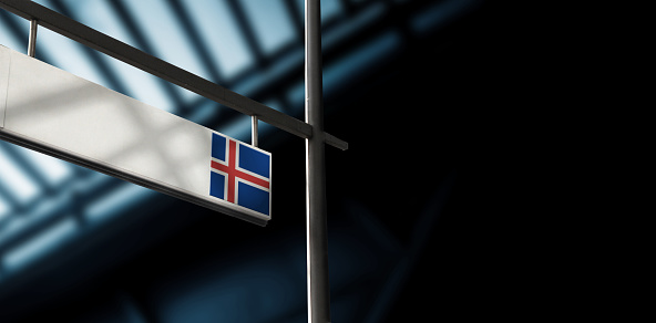 Flag of Iceland on airport departure information board. Close-up. Roof construction in the background. Blue color. Horizontal orientation. Ne people. Copy space.