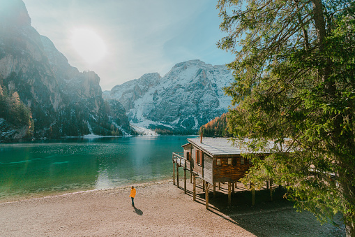 Young caucasian woman walking  and looking at Lago di Braies in winter