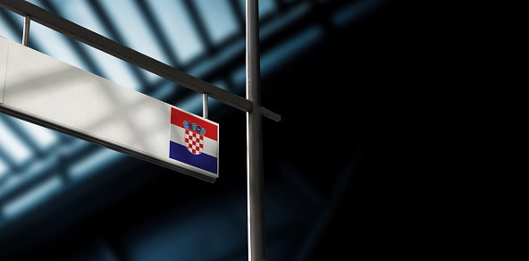 Flag of Croatia on airport departure information board. Close-up. Roof construction in the background. Blue color. Horizontal orientation. Ne people. Copy space.