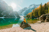 Woman  sitting on the background of  Lago di Braies in winter