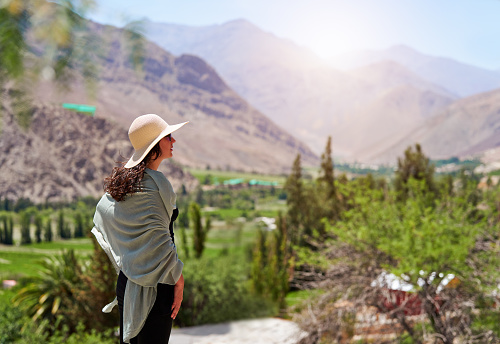 Latin woman tourist looking at the sunny landscape in Paihuano, Valle del Elqui