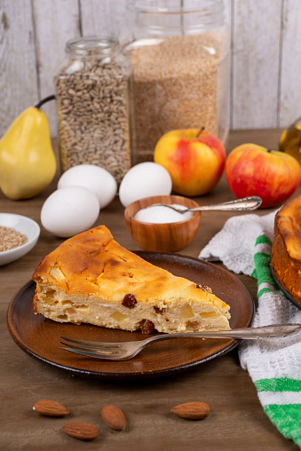 Cheesecake with raisins and apples on a table with ingredients