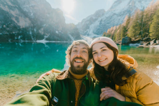 selfie de hombre y mujer cerca del lago di braies en invierno - heterosexual couple fotografías e imágenes de stock
