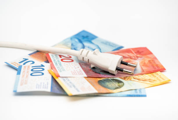 Swiss banknotes and a power plug stock photo