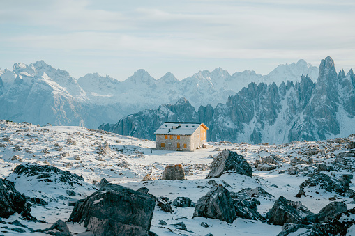 Scenic view of alpine shelter in snow-covered Dolomites in winter