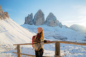 Woman hiking  on the background of Tre Cime di Lavaredo in winter