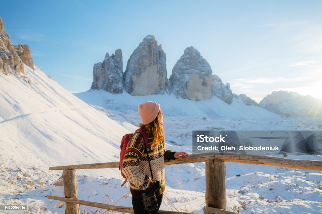 Woman hiking  on the background of Tre Cime di Lavaredo in winter Young Caucasian woman hiking on the background of Tre Cime di Lavaredo in winter Winter Stock Photo