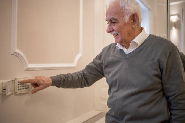 istock Senior man adjusts the temperature at home with a device on the wall 1450054877