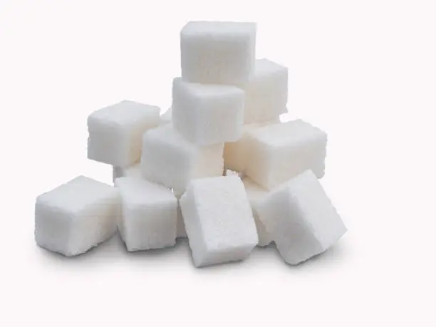 Refined sugar, folded in a hill, on a white background.