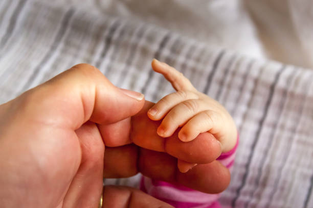istock baby handhold on grandpa's finger 1450062641