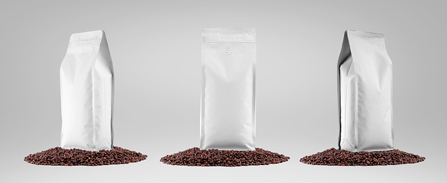 White coffee pouch mockup, presentation on coffee beans, isolated on background. Package set with degassing valve for product aroma. Packaging template for a drink, for advertising in a coffee shop.