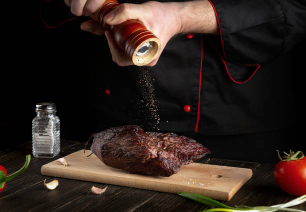 istock The chef sprinkles the baked beef meat with pepper. Working environment on the kitchen table. Asian cuisine 1450066707