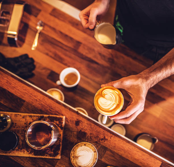 Man preparing coffee at table in cafe