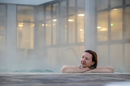 Shot of a mid-adult woman relaxing in the thermal pool at a spa