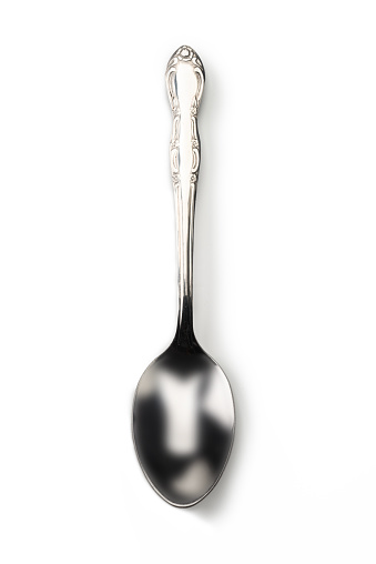 Single spoon agains a white background, high angle view