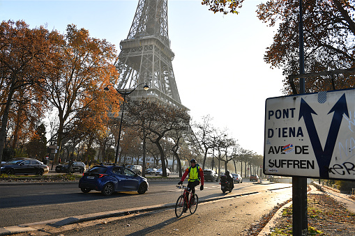 Paris, France-12 16 2022: People riding bicycle passes near the Eiffel tower in Paris, France.