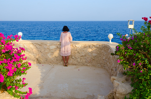 Sharm El Sheikh, Egypt - September 16, 2020: Unknown girl admires beautiful view at Stella Di Mare Sharm Beach Hotel & Spa 5 * in Naama Bay, Sharm El Sheikh, Egypt