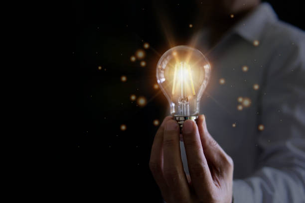 istock Businessman holding a glowing light bulb. 1450080825