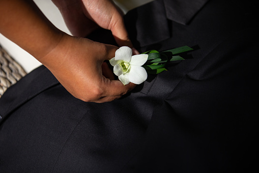 Orchid flower embroidered on a black suit with meticulousness and determination The colors of light pass through the flowers. to prepare for the celebration of the ceremony