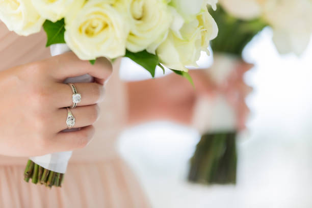 brautjungfern mit blumensträußen mit einer rose in der hand, um an der hochzeit teilzunehmen sie trug einen diamantring und einen herzförmigen ring und sah wunderschön aus. - cluster verlobungsringe stock-fotos und bilder