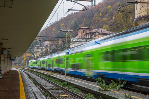 Como train station  in Northern  Italy . Moving  train (perhaps  from Switzerland )