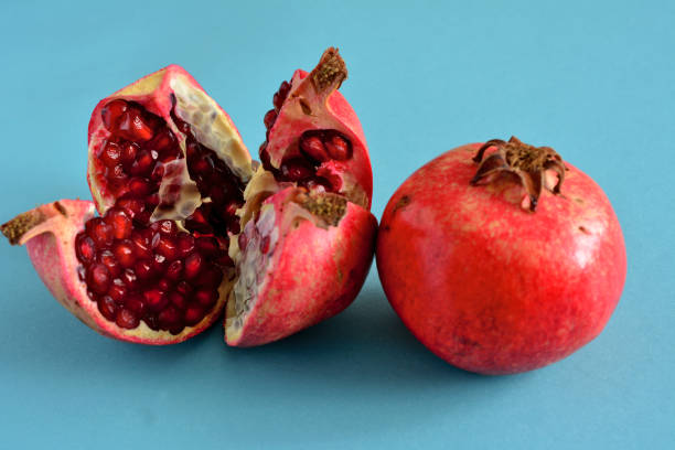istock pomegranate fruit with seeds isolated on blue background, macro 1450085910